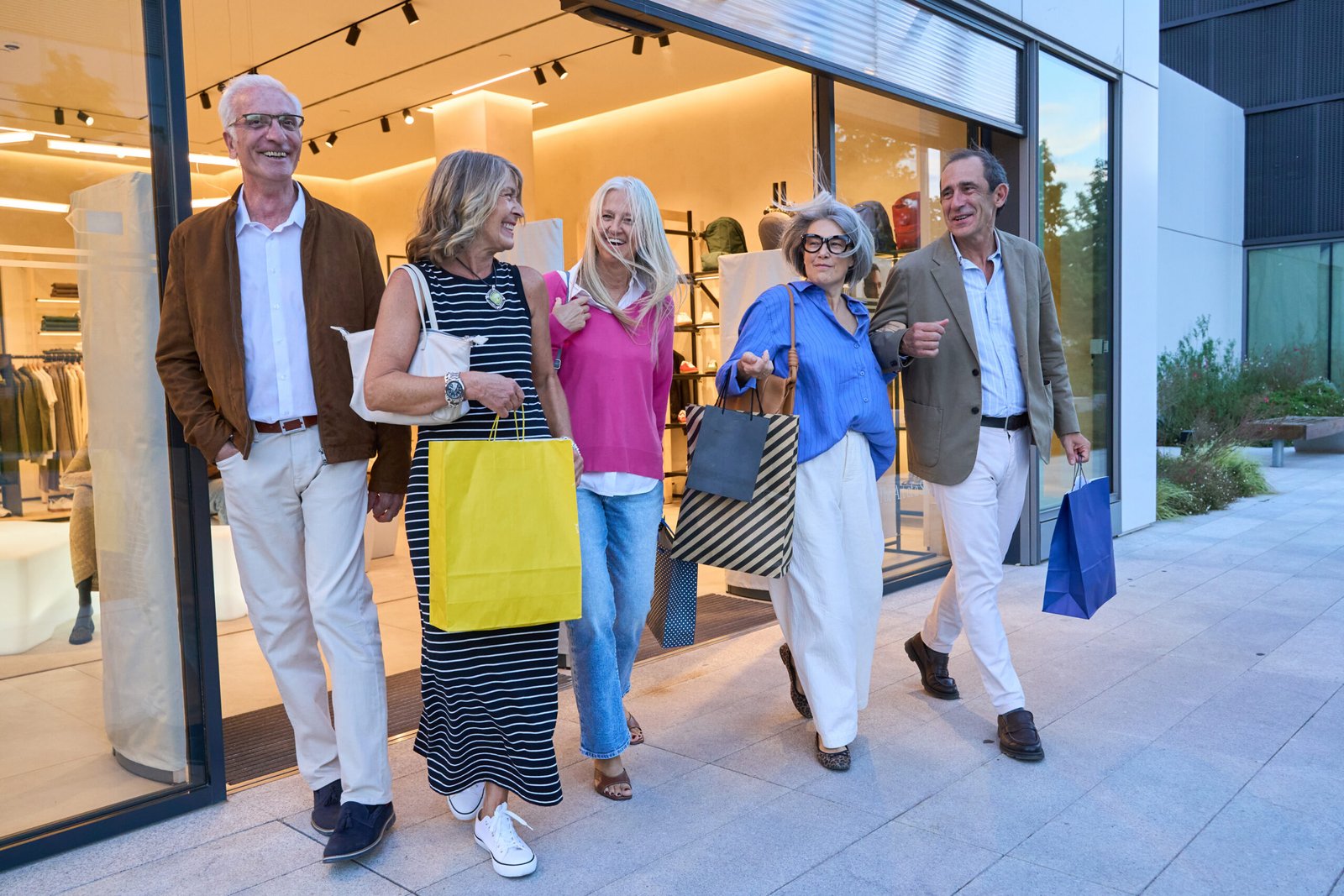 A group loading shopping bags into a shuttle bus at an outlet mall